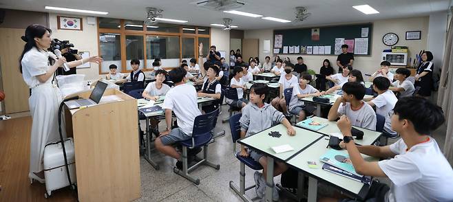 [이데일리 이영훈 기자] 15일 서울 양천구 양정중에서 열린 '경제·금융교육 공개수업'에서 교사가 수업을 진행하고 있다.이번 공개수업은 통화량과 물가의 관계라는 추상적인 경제 개념을 학생이 직접 몸으로 겪는 실험을 통해 이해하도록 설계됐다. 바둑알을 화폐 삼은 모의 경매에서 학생들은 시중에 풀린 돈의 양이 늘어날수록 같은 물건의 가격이 뛰는 과정을 직접 목격하고, 이를 역사적 사례와 경제학자의 이론으로 확장해 학습한다.