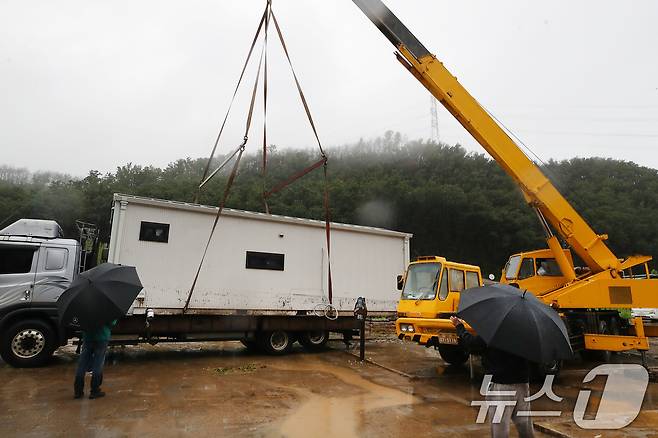 19일 경북 안동시 일직면 귀미리 산불 이재민 주거용 임시 주택 일대가 집중호우로 침수된 가운데 수해 복구 현장에 다시 폭우가 쏟아지자 크레인과 트럭을 동원해 주택을 인근 폐교로 옮기고 있다. 2026.7.19 ⓒ 뉴스1 공정식 기자