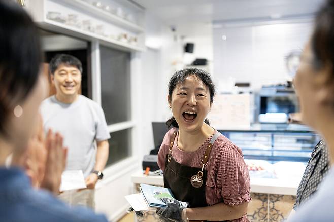 정식 개점일에 불광문고 수련점을 찾은 이들과 대화하며 장수련 점장이 환하게 웃고 있다.