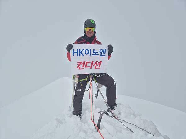 정상에서 후원사 깃발을 들고 등정 사진을 찍은 안치영 대장.