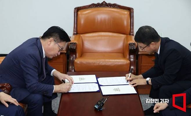 한병도 더불어민주당 대표 직무대행 겸 원내대표와 정점식 국민의힘 원내대표가 21일 국회 운영위원장실에서 선관위 투표용지 부족사태에 따른 특검법안 합의문에 서명하고 있다. 2026.7.21 김현민 기자
