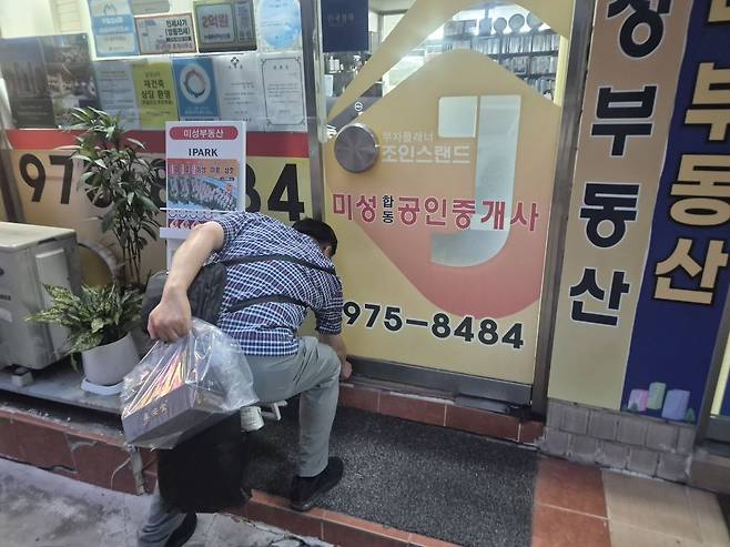 김우정 미성공인중개사 대표가 16일 오후 8시 사무실 문을 닫고 퇴근하고 있다. 이강민 기자