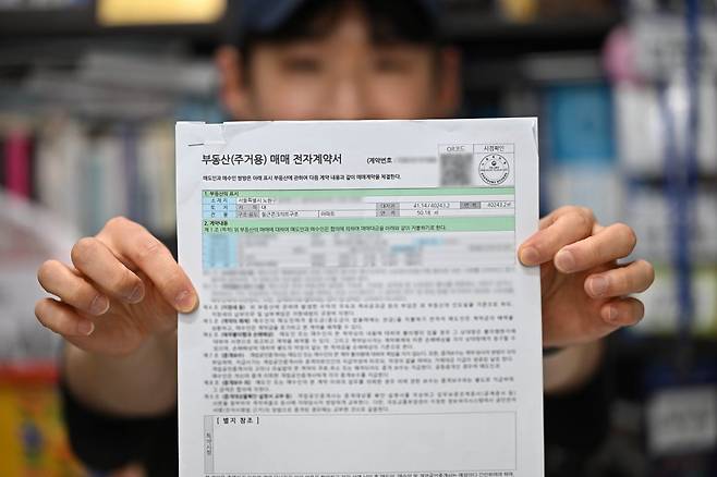 30대 초반 B가 지난 16일 서울 노원구의 미성합동공인중개사 사무소에서 부동산 매매 전자계약서를 보여주고 있다. B는 이날 미미삼 단지의 한 아파트 계약 잔금을 치렀다. 윤웅 기자
