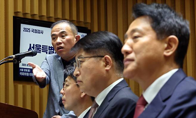 정치 브로커 명태균 씨가 작년 10월 23일 서울 중구 서울시청에서 열린 2025년 국회 행정안전위원회 국정감사에서 의원 질의에 답하고 있다. 오른쪽은 오세훈 서울시장. [연합뉴스]