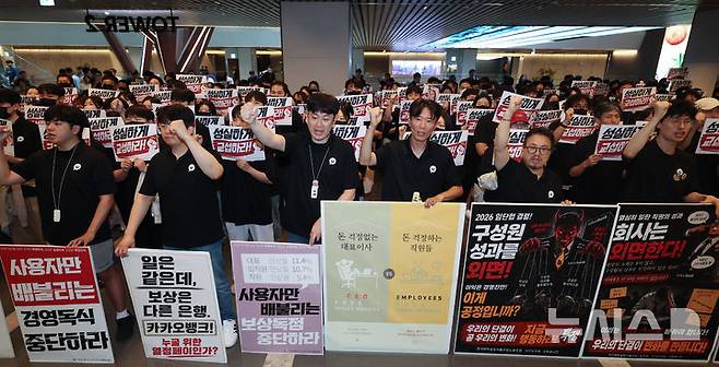 [성남=뉴시스] 김명년 기자 = 민주노총 화섬식품노조 카카오지회 조합원들이 21일 카카오뱅크가 입주한 경기 성남시 판교테크원에서 사측의 임금 인상률과 성과급 등 보상 체계를 규탄하는 피켓 시위를 열고 구호를 외치고 있다. 2026.07.21. kmn@newsis.com