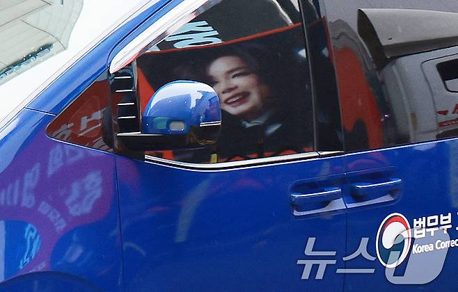 김건희 여사를 태운 호송차가 22일 경기 과천 2차 종합특검 사무실 지하주차장으로 들어서고 있다. 김여사가 탄 차량에 지지자들이 걸은 김여사 사진이 비춰지고 있다. 2차 종합특검팀(특별검사 권창영)은 이날 윤석열 전 대통령 관저 이전과 관련 특정범죄가중처벌법상 알선수재와 직권남용 혐의로 김 여사를 피의자 신분으로 소환했다. 2026.7.22 ⓒ 뉴스1 이호윤 기자