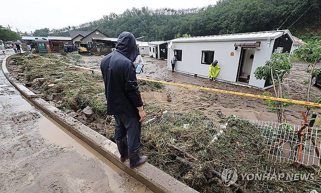 망연자실 (안동=연합뉴스) 윤관식 기자 = 지난 19일 경북 안동시 일직면 귀미1리에 설치된 산불 이재민 임시주택단지에서 한 주민이 폭우로 인한 토사에 뒤덮인 마을을 살펴보고 있다. 2026.7.19 psik@yna.co.kr