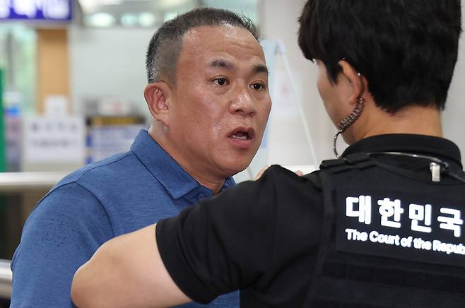 여론조사를 무상으로 받은 혐의로 기소된 윤석열 전 대통령의 1심 결과가 선고된 지난 13일 윤 전 대통령에게 여론조사를 무상으로 제공한 정치 브로커 명태균씨가 서울 서초구 서울중앙지법에서 열린 선고 공판에 출석하고 있다. 명씨는 이날 징역 1년 6개월을 선고받고 법정구속됐다. 2026.7.13 [사진=연합뉴스]