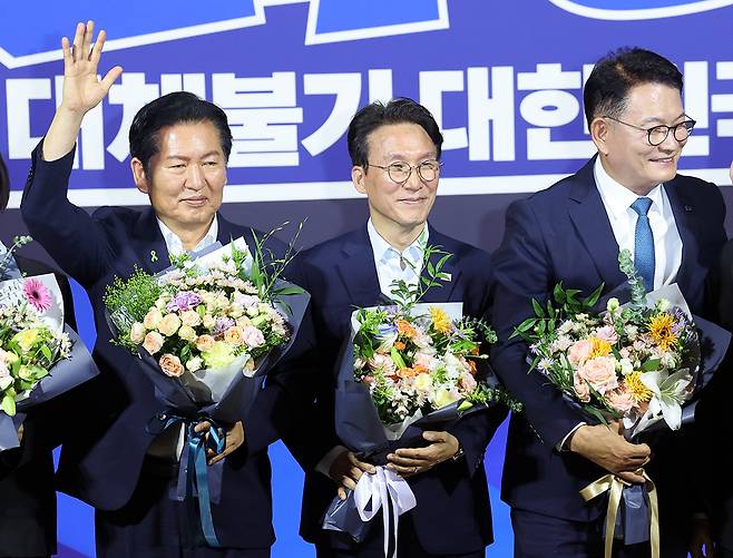 더불어민주당 8·17 전당대회 대표 경선에 진출한 정청래(왼쪽부터), 김민석, 송영길 후보가 23일 여의도 국회의원회관에서 열린 당대표·최고위원 선출을 위한 예비경선 결과발표에서 꽃다발을 들고 있다. 뉴시스