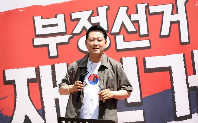 국민의힘 장동혁 대표가 25일 오후 경남 김해시 내동 거북공원에서 열린 6·3 참정권 침해 규탄 김해시민 집회에서 연설하며 태극기가 그려진 옷을 보여주고 있다. 김해=연합뉴스