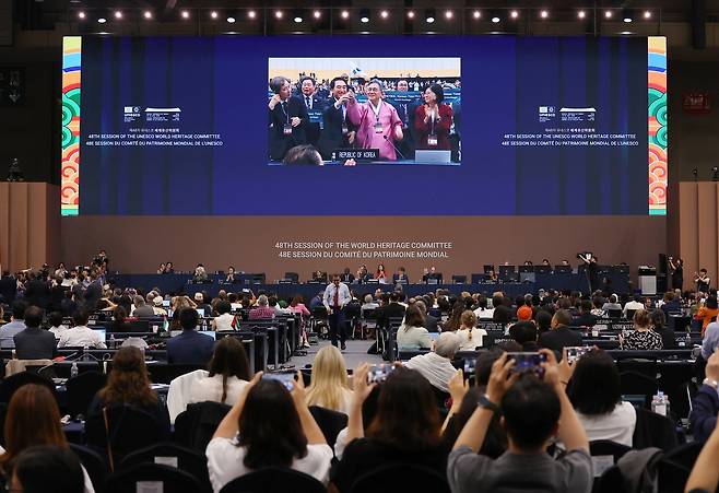허민 국가유산청장이 25일 부산 ‘제48차 유네스코 세계유산위원회’ 본회의에서 ‘한국의 갯벌 2단계’ 등재를 축하하며 태극기를 흔들고 있다. 연합뉴스
