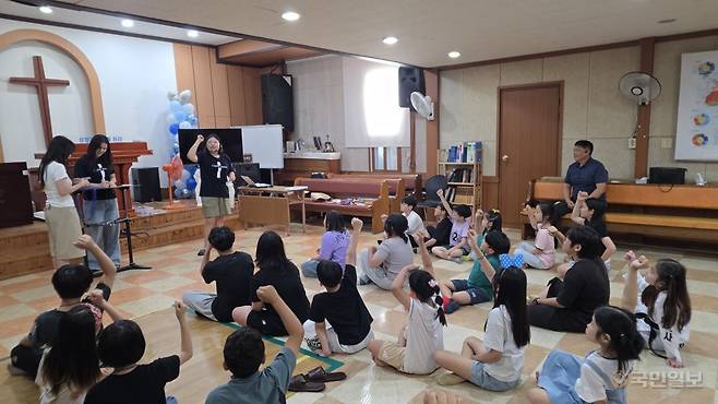 김진은(오른쪽 의자에 앉은 이) 목사가 지난 24일 충남 아산시 인주면 서광감리교회 예배당에서 여름성경학교에 참가한 아이들의 모습을 바라보고 있다.