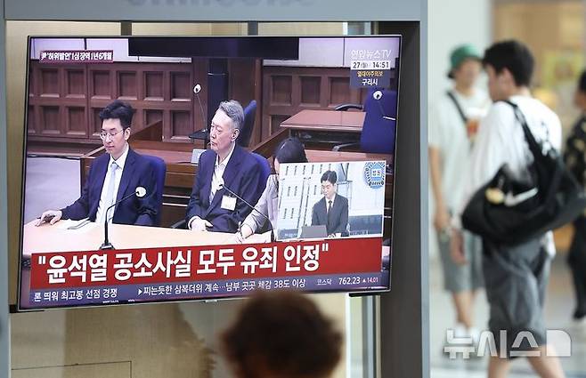 [서울=뉴시스] 김명년 기자 = 대선후보 시절 건진법사 전성배 씨에 관한 허위사실을 공표한 혐의로 기소된 윤석열 전 대통령 1심 선고 공판이 열린 27일 서울역에서 시민들이 관련 방송을 지켜보고 있다. 이날 재판부는 윤 전 대통령에게 징역 1년 6개월에 집행유예 3년을 선고했다. 2026.07.27. kmn@newsis.com