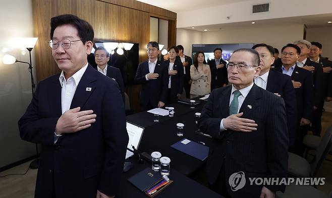 이재명 대통령, 브라질에서 대수보 주재 (브라질리아=연합뉴스) 한상균 기자 = 브라질을 국빈 방문 중인 이재명 대통령이 26일(현지시간) 브라질리아 한 호텔에서 열린 화상 수석보좌관회의에서 국기에 경례하고 있다. 2026.7.27 xyz@yna.co.kr