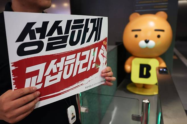 민주노총 화섬식품노조 카카오지회 조합원들이 21일 카카오뱅크가 입주한 경기 성남시 판교테크원에서 사측의 임금 인상률과 성과급 등 보상 체계를 규탄하는 피켓 시위를 하고 있다. 뉴시스