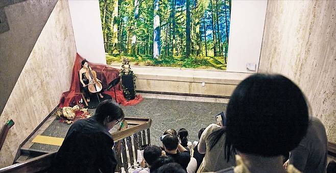 첼리스트 홍채원(왼쪽)이 세종문화회관 계단에 앉은 관객들 앞에서 리게티의 첼로 소나타를 연주하고 있다. /세종문화회관