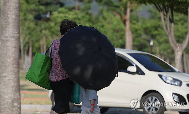 양산 낮 최고…40.3도  경남 양산지역 낮 최고기온이 40.3도까지 치솟은 29일 오후 양산시 물금읍 황산공원 주차장에서 시민이 양산으로 얼굴을 가린 채 이동하고 있다.  [연합뉴스 자료사진]