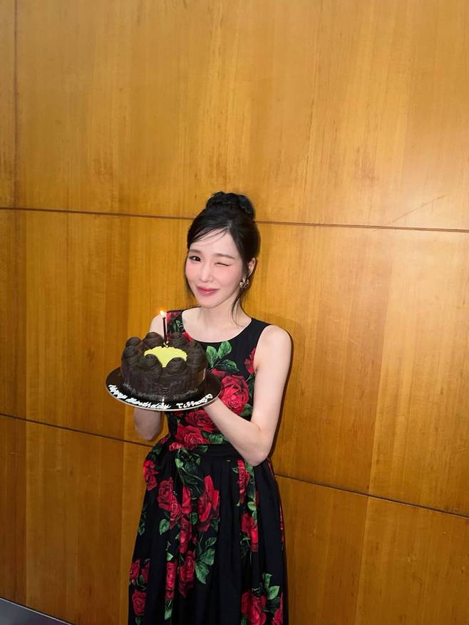Girls Generation member Tiffany Young shared photos on her social media of her first birthday party since marrying actor Byun Yo-han. Wearing a glamorous dress and a cake, Tiffany Young spent a joyful time in a pink-themed setting, beaming with a bright smile.In the photos released, Tiffany Young is seen holding a cake featuring her face with a happy expression, while in another picture, she appears relaxed, wearing a rose-patterned dress and winking. Tiffany Young and actor Byun Yo-han officially became a legally married couple last February after registering their marriage.