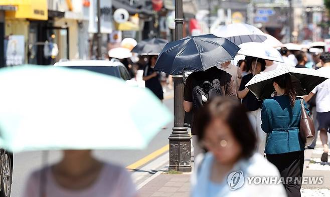 우산으로 뙤약볕을 피하는 시민들 [연합뉴스 자료사진]