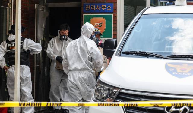 23일 오전 8시 29분께 경북 경산시 사동 한 아파트 관리실 안에서 폭발 추정 사고가 난 가운데 경찰 과학수사대가 증거물로 보이는 물건을 담은 종이상자를 가지고 철수하고 있다. 연합뉴스