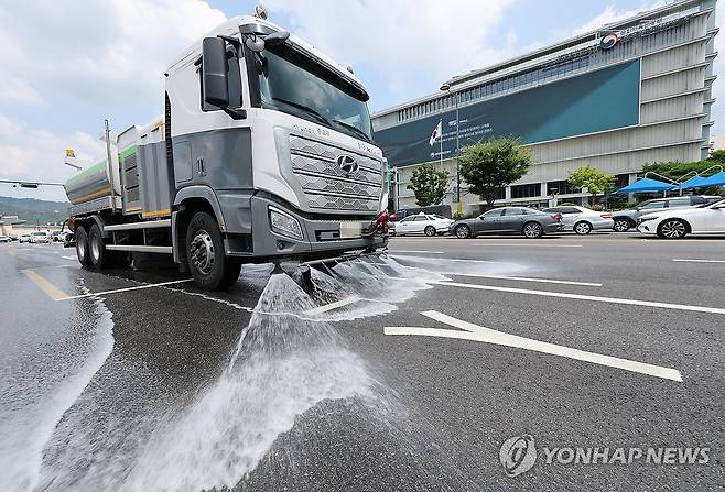 달아오른 아스팔트를 식혀라 (서울=연합뉴스) 박동주 기자 = 서울에 첫 '폭염중대경보'가 발령된 4일 서울 시내에서 종로구 도로 물청소차 작업자가 아스팔트를 식히는 살수 작업을 하고 있다. 2026.8.4 pdj6635@yna.co.kr