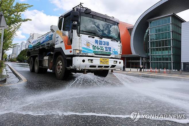 달궈진 도로 식히는 살수차 (전남광주=연합뉴스) 조남수 기자 = 폭염 특보가 연일 발효되고 있는 29일 전남광주통합특별시 서구 치평동에서 구청 안전총괄과 관계자가 살수차를 이용해 달궈진 도로에 물을 뿌리고 있다. 2026.7.29 iso64@yna.co.kr