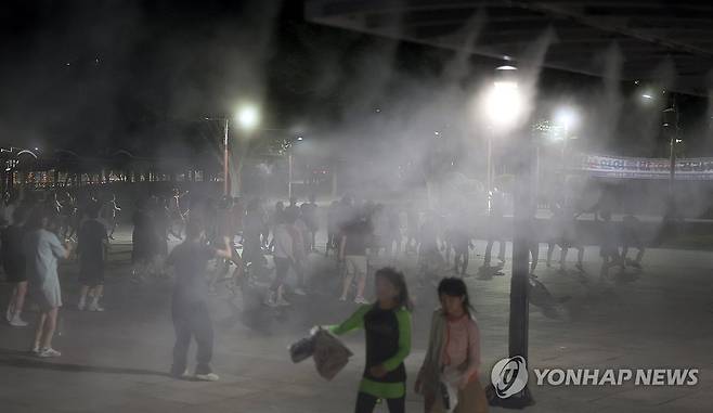 쿨링포그 작동하는 밤 지난달 29일 오후 경남 양산시 물금읍 양산워터파크에서 열린 건강 체조 교실에서 많은 시민이 안개형 냉각수(쿨링포그) 도움을 받아 체조하고 있다.