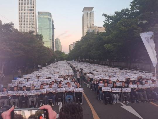 11일 저녁 산업은행 앞 국회의사당대로변에 모인 산업은행, 기업은행, 수출입은행 등 3사 노동조합원들과 직원들이 피켓을 들어보이고 있다. / 사진=장호성 기자