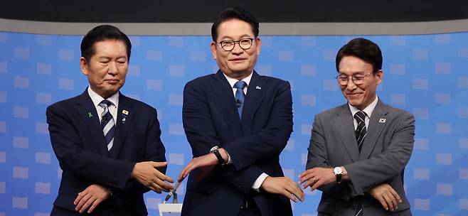 “자, 손잡으시죠” 정청래·송영길·김민석 더불어민주당 당대표 후보(왼쪽부터)가 12일 서울 양천구 SBS 목동 스튜디오에서 열린 TV 토론회에 참석해 손잡고 기념촬영을 하고 있다. 국회사진기자단