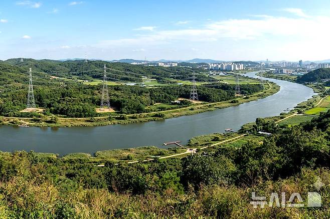 [전남광주=뉴시스] 정부와 한전은 현재 건설 중인 신장성변전소와 광주 군공항 이전 부지를 연결하는 신규 송전망을 지방도 49호선인 '빛가람장성로'와 황룡강변을 따라 설치하는 방안을 우선 검토하고 있다. 그림은 '황룡강변 송전선로 상상도'  (이미지=생성형 AI 제작) *재판매 및 DB 금지
