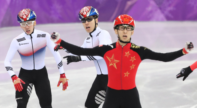 중국 우다징이 2018 평창동계올림픽 남자 쇼트트랙 500m 결승에서 한국 황대헌과 임효준을 제치고 가장 먼저 골인한 뒤 기뻐하고 있다. 연합뉴스