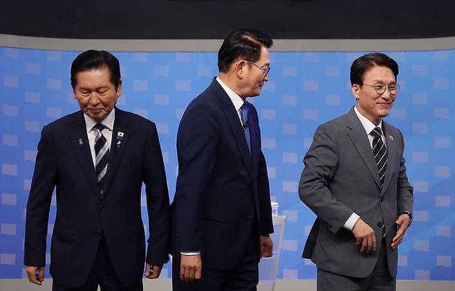 더불어민주당 정청래·송영길·김민석 당대표 후보(왼쪽부터)가 12일 TV토론회 시작에 앞서 기념촬영을 마친 뒤 자리로 돌아가고 있다. [국회사진기자단]