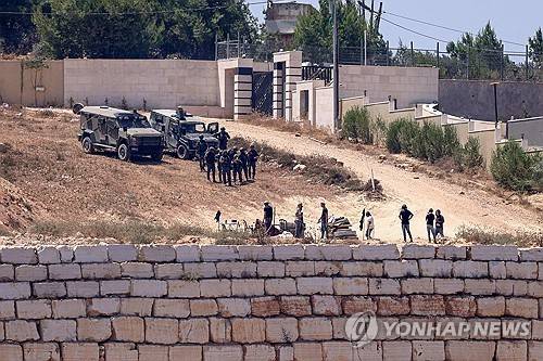 요르단강 서안지구 나블루스 남쪽 쿠스라 마을에서 이스라엘 군인들(사진 위)이 팔레스타인 가옥 앞에 자리 잡은 유대인 정착민들 옆에서 경계를 서고 있다. [AFP 연합뉴스. 재판매 및 DB 금지]