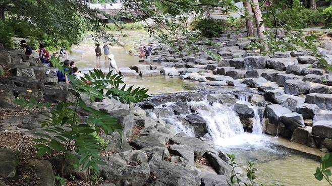 People dip their feet into the cool stream of Dobong Valley SCREEN CAPTURE