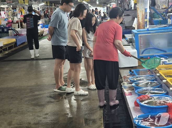 광복절 연휴인 15일 강원 동해안 최대 어항인 주문진항 어민수산시장을 방문한 가족 나들이객이 횟감을 고르고 있다. 2026.8.15/뉴스1 윤왕근 기자