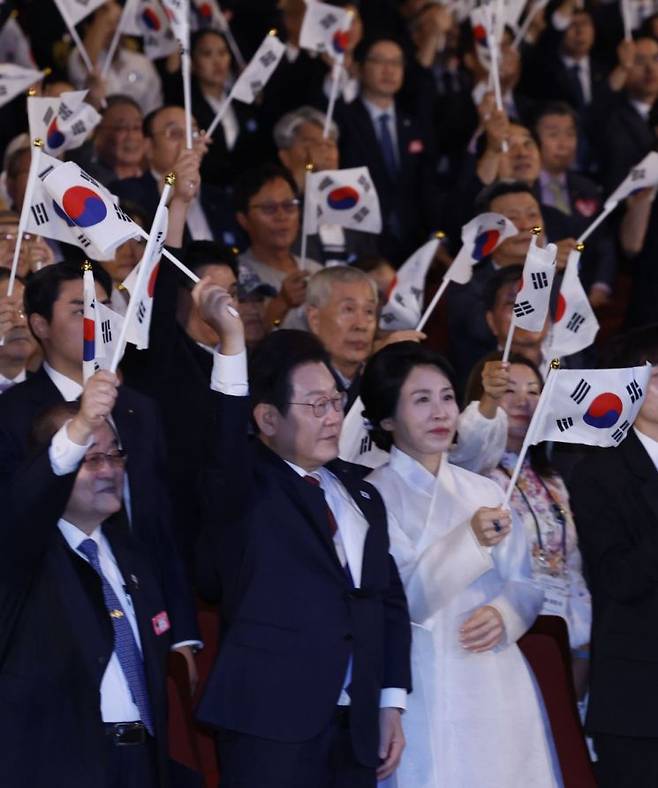 이재명 대통령과 김혜경 여사가 15일 서울 세종문화회관에서 열린 80주년 광복절 경축식에서 참석자들과 만세 삼창을 한 뒤 태극기를 흔들고 있다. 2025.8.15 [대통령실통신사진기자단] 연합뉴스