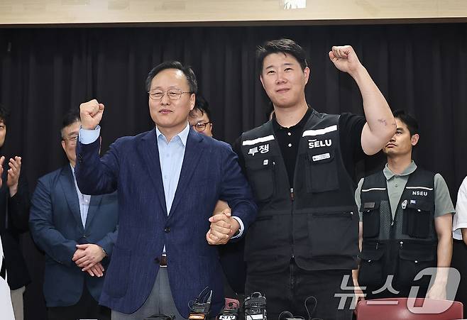 20일 경기 수원시 장안구 경기고용노동청에서 열린 삼성전자 임금협상을 마친 후 여명구 삼성전자 DS(디바이스솔루션·반도체 사업 담당) 피플팀장과 최승호 삼성그룹 초기업노동조합 삼성전자지부 위원장이 잠정 합의안에 서명한 후 파이팅을 외치고 있다. (공동취재) 2026.5.20 ⓒ 뉴스1 김영운 기자