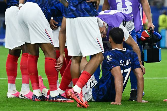 France's defender #17 William Saliba (R) receives medical attention as he sits injured on the pitch during the 2026 World Cup football tournament semi-final match between France and Spain at the Dallas Stadium in Arlington on July 14, 2026.  (Photo by RONALDO SCHEMIDT / AFP)  <저작권자(c) 연합뉴스, 무단 전재-재배포, AI 학습 및 활용 금지>