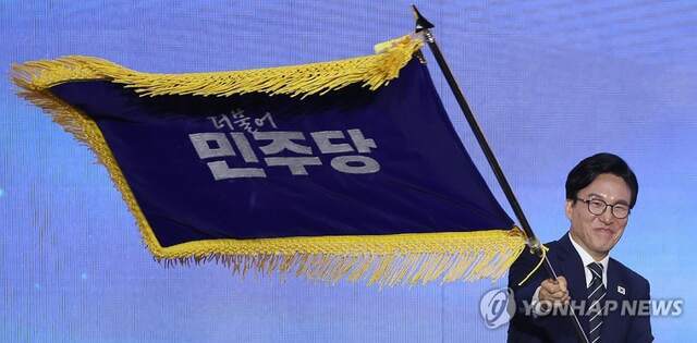 더불어민주당 김민석 신임 당 대표가 17일 대전 컨벤션센터에서 열린 제3회 더불어민주당 정기 전국당원대회에서 당 대표로 선출된 뒤 당기를 흔들어 보이고 있다./사진=연합뉴스