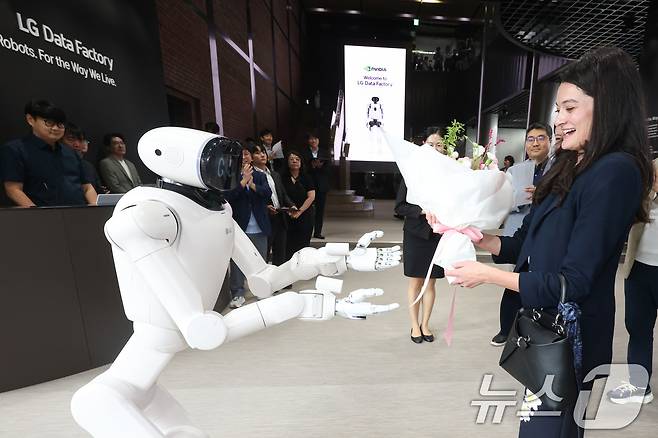 젠슨 황 엔비디아 최고경영자(CEO)의 장녀인 매디슨 황 엔비디아 수석이사가 18일 서울 서초구 LG 데이터팩토리를 방문, 'LG 클로이드(CLOiD)' 로봇으로부터 꽃다발을 받고 있다. (LG전자 제공. 재판매 및 DB금지) 2026.8.18 ⓒ 뉴스1
