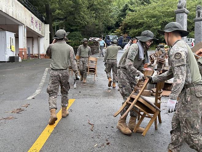 육군은 최근 집중호우로 피해를 입은 경남지역 주민들의 빠른 일상 회복을 위해 수해복구 대민 지원에 나섰다고 18일 밝혔다. 육군 제39보병사단 장병들이 경남 통영시 봉평동 봉수로 일대에서 민간 주택과 상가 주변에 쌓인 잔해물을 제거하며 주민들의 빠른 일상 회복을 지원하고 있다. 육군 제공