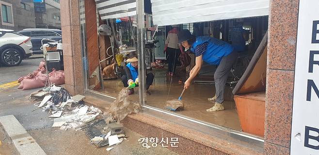 18일 경남 거제시 옥포동 한 미용실에서 자원봉사자들이 흙탕물을 쓸어내고 있다. 김정훈 기자