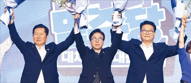 김민석(가운데) 더불어민주당 신임 대표가 17일 대전시 유성구 대전컨벤션센터(DCC) 제2전시장에서 열린 제3차 정기전국당원대회에서 경쟁자였던 정청래(왼쪽) 후보, 송영길 후보와 손을 맞잡고 당원들에게 인사하고 있다. 대전=최현규 기자