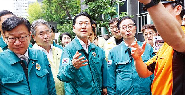 국민의힘 장동혁(가운데) 대표와 정점식(왼쪽) 원내대표가 18일 폭우 피해를 입은 경남 통영의 한 아파트 지하주차장 침수 현장을 찾아 소방대원의 설명을 듣고 있다. 연합뉴스