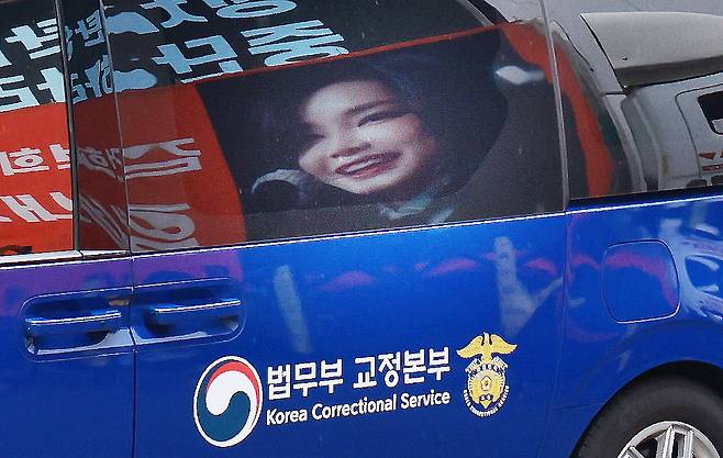 김건희 여사를 태운 호송차가 지난달 22일 경기 과천 2차 종합특검 사무실 지하주차장으로 들어서고 있다. 김여사가 탄 차량에 지지자들이 마련한 김 여사 사진이 비춰지고 있다. 2차 종합특검팀(특별검사 권창영)은 이날 윤석열 전 대통령 관저 이전과 관련 특정범죄가중처벌법상 알선수재와 직권남용 혐의로 김 여사를 피의자 신분으로 소환했다./사진=뉴스1