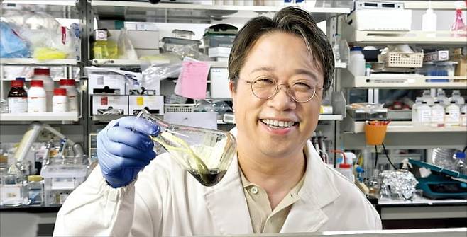 이해신 교수가 ﻿대학 실험실에서 폴리페놀 시료가 든 용기를 ﻿들어 보이고 있다.