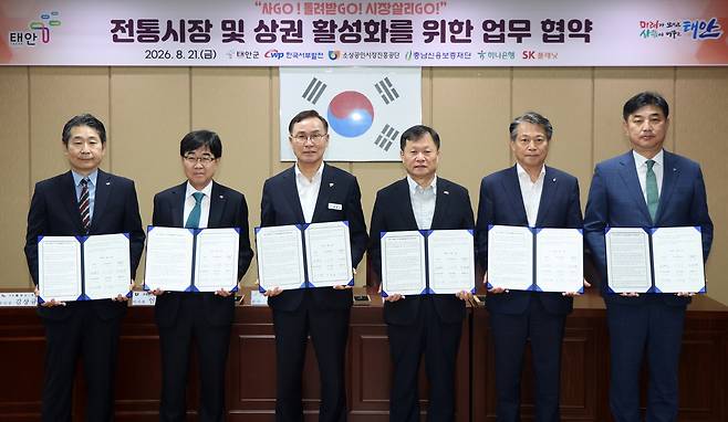 태안군 경제활성화를 업무협약식 모습(왼쪽부터 김상규 SK플래닛 VAS유닛장, 인태연 소상공인시장진흥공단 이사장, 윤희신 태안군수, 이정복 한국서부발전 사장, 조소행 충남신용보증재단 이사장, 이동열 하나은행 충청그룹 대표(부행장)
