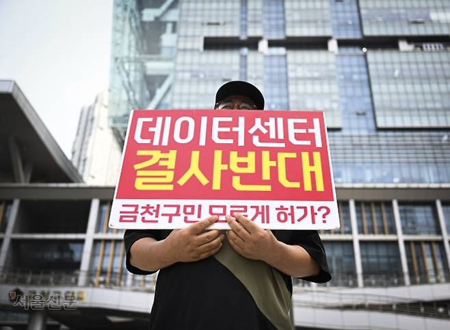 서울 금천구 독산동에 거주하는 한 주민이 지난 19일 금천구청 앞에서 ‘데이터센터 결사반대’ 피켓을 들고 데이터센터 반대 집회에 참여하고 있다.  이지훈 기자