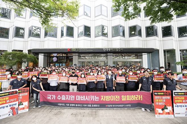 무역보험공사 노동조합원들이 지난 24일 서울 무보 본사 앞에서 지방이전을 반대하는 피켓을 들고 있다. (사진=무보 노조)