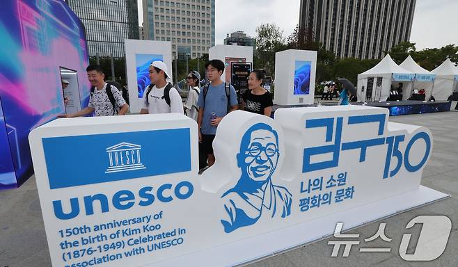 26일 서울 종로구 광화문 광장에서 관광객들이 ‘김구 탄생 150주년 조형물’을 살펴보고 있다. 고 밝혔다. 2026.8.26 ⓒ 뉴스1 이종덕 기자